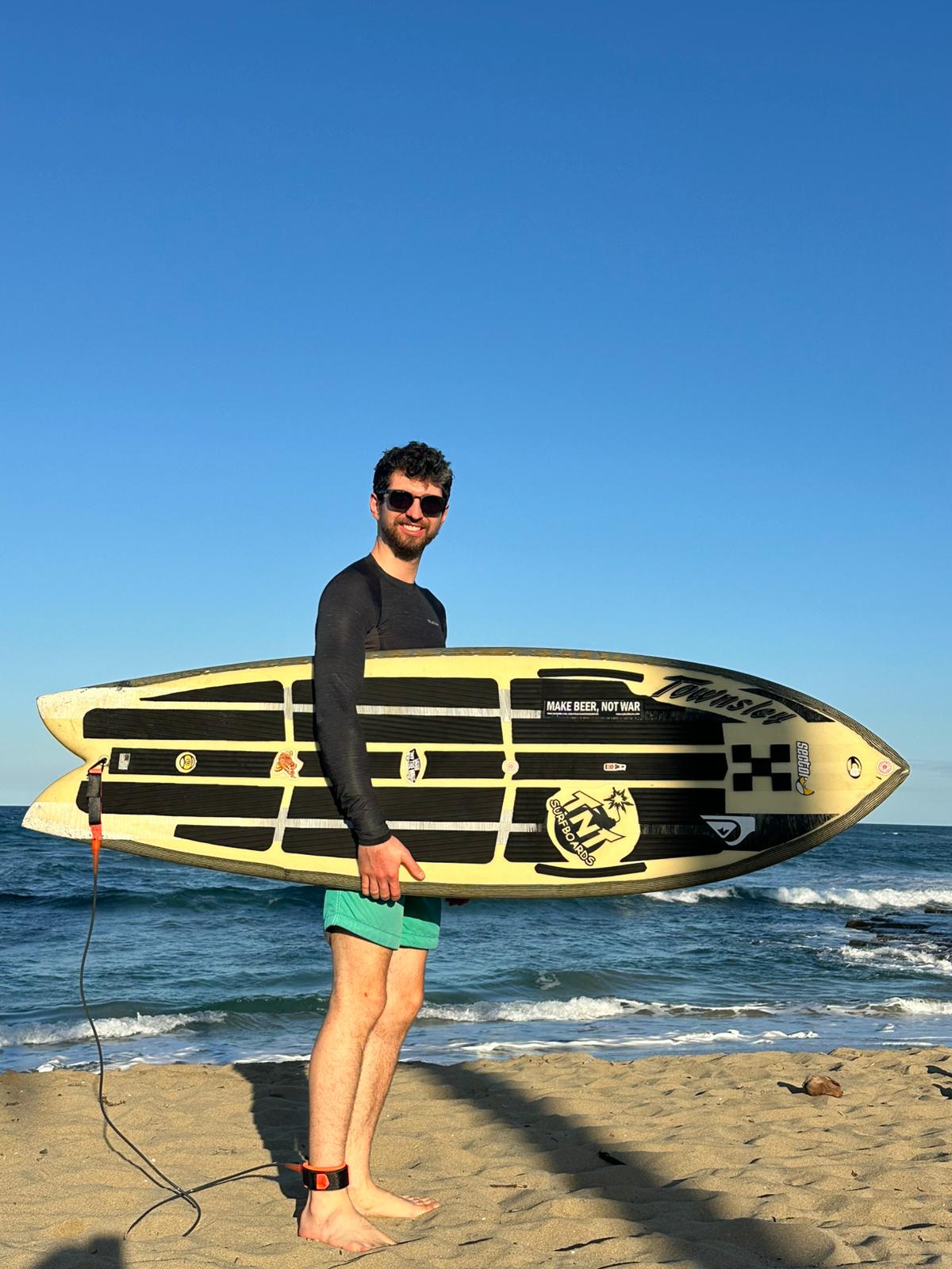 Alexandre at the beach with a surfboard